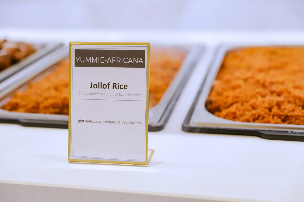 Een goudkleurig kaartje met Jollof Rice bij een bak jollof